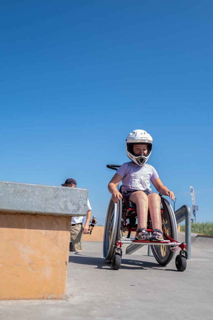 Ein Mädchen im Rollstuhl im Skatepark.
