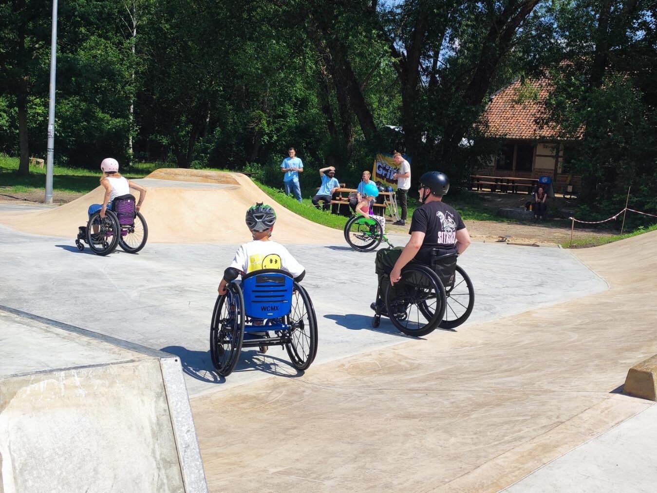 In einem Skatepark sind mehre Personen im Rollstuhl.